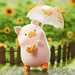 LuLu the Piggy's Travel Series Blind Box pig figure holding a cat-shaped umbrella in a rainy day scene