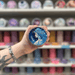 Luna wax melt pot held in hand with colourful wax melt display in the background