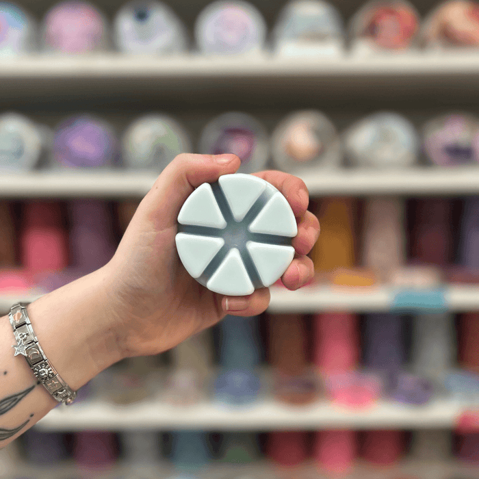 Luna wax melt segments held in hand with colourful wax melt display in the background