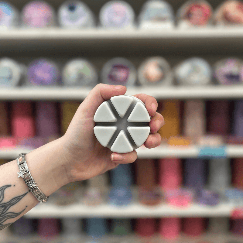 Mandarin and Sandalwood grey segmented wax melt held in hand