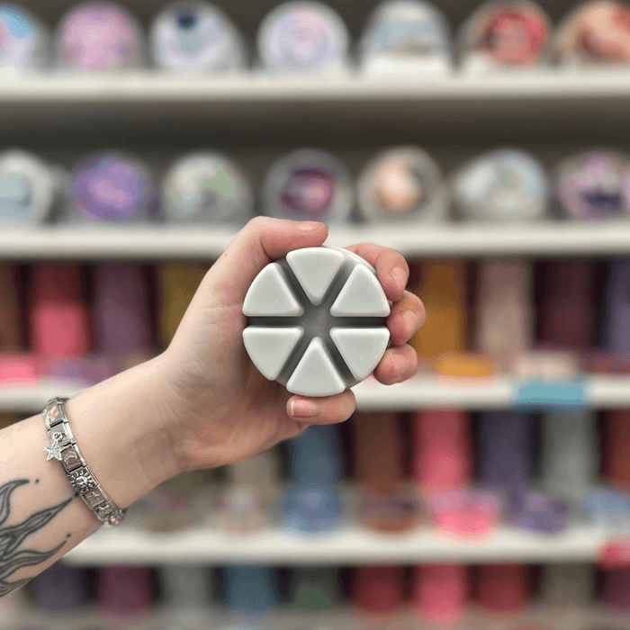 Mandarin and Sandalwood grey segmented wax melt held in hand