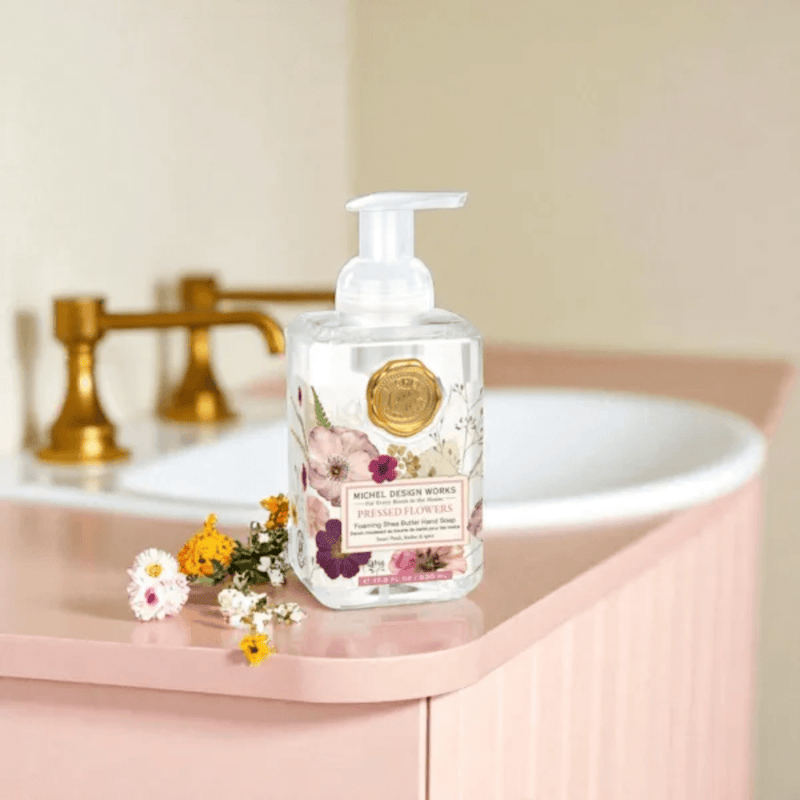 Michel Design Works Pressed Flowers foaming hand soap 530ml on bathroom counter beside sink with flowers