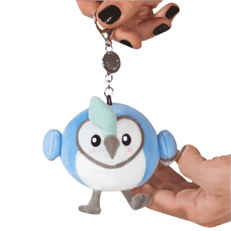 Front view of the Micro Squishable Blue Jay plush keychain with blue wings, white face and metal clip
