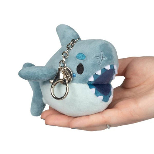 Micro Squishable Megalodon plush keychain in blue-grey with open mouth and metal clip, held in hand