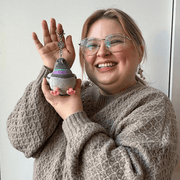 Micro Squishable Pigeon plush keychain being held for size comparison