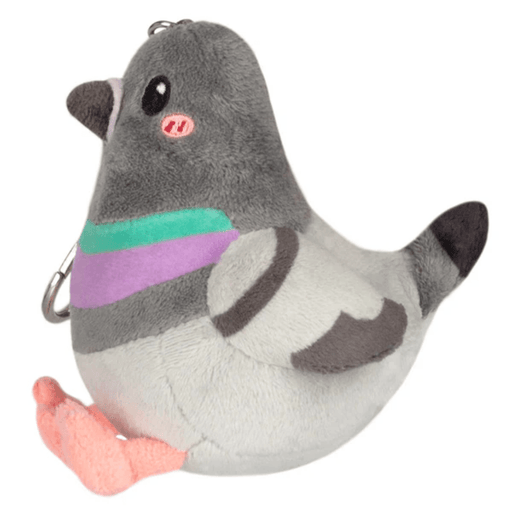 Side view of the Micro Squishable Pigeon plush keychain showing grey wings, tail and pink feet
