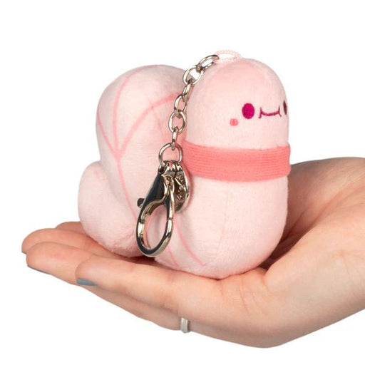 Micro Squishable Worm plush keychain in pink with clip and chain, held in hand