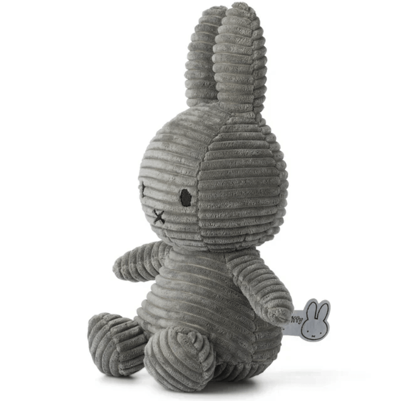 Angled side view of grey corduroy Miffy plush rabbit, 23 cm, showing ribbed texture.
