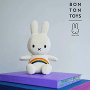 Miffy Rainbow white corduroy plush toy by Bon Ton Toys displayed on books