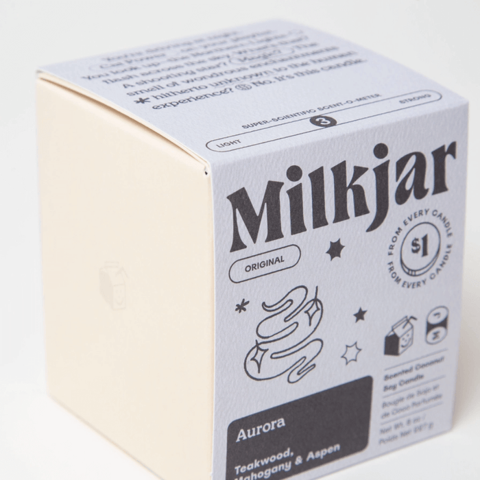 Close-up of Milkjar Aurora candle box front showing Mahogany, Teakwood and Aspen scent.