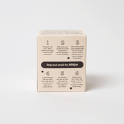 Back of Milkjar candle box showing wick trimming and burn care tips, Stop and smell the Milkjar.