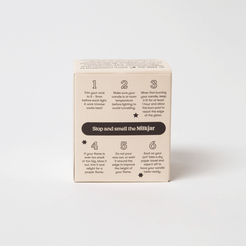 Back of Milkjar candle box showing wick trimming and burn care tips, Stop and smell the Milkjar.