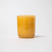Milkjar Before Sunrise candle in an amber glass jar on a white background