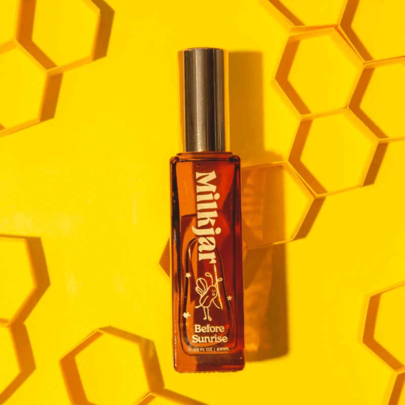 Milkjar Before Sunrise Milk & Honey 20ml perfume roller bottle on yellow honeycomb background
