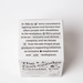 Back of The Feel-Good Candle Co box with inclusive workplace and $1 donation message.