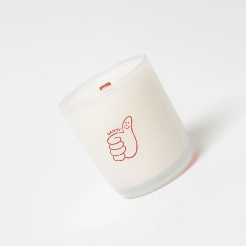 Milkjar Dandy coconut soy candle 8oz photographed at an angle on a white background with wooden wick and Dandy icon.