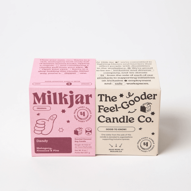 Milkjar Dandy candle box (mahogany, firewood and pine) beside The Feel-Gooder Candle Co. packaging on a white background.