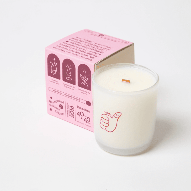 Milkjar Dandy coconut soy candle 8oz photographed at an angle on a white background with wooden wick and Dandy icon.