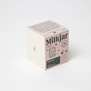 Angled view of Milkjar Golden Hour candle box showing Cashmere, Cedarwood and Musk scent.