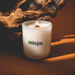 Lit Milkjar candle in frosted glass with wooden wick, styled with warm wood tones in the background.
