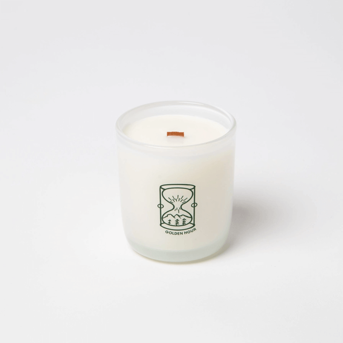 Milkjar Golden Hour coconut soy candle in frosted glass with wooden wick on a white background.