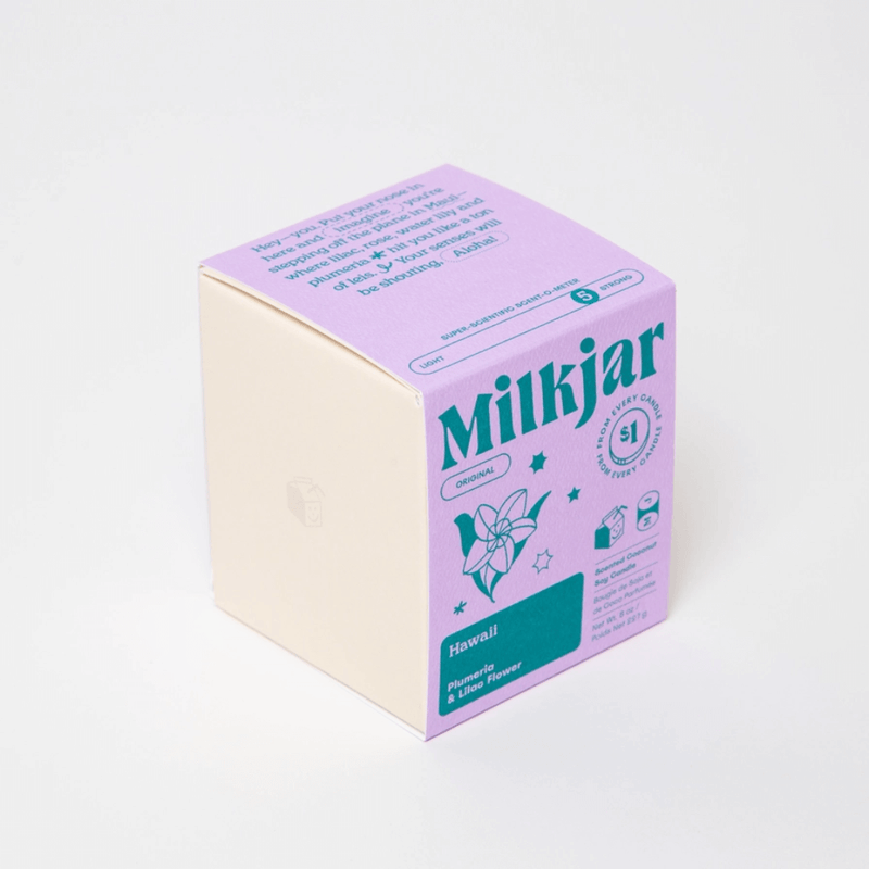 Angled view of Milkjar Hawaii candle box showing Plumeria and Lilac Flower scent on a white background.