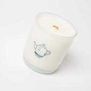 Milkjar Hygge coconut soy candle 8oz photographed at an angle on a white background with wooden wick and Hygge icon.
