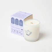 Milkjar Hygge candle with box angled behind, showing wooden wick, fragrance oil and coconut soy wax icons.