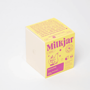Milkjar Sunnyside candle beside the box showing icons for wooden wick, fragrance oils and coconut soy wax.