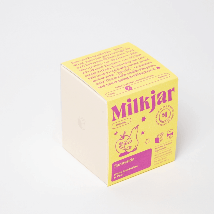 Milkjar Sunnyside candle beside the box showing icons for wooden wick, fragrance oils and coconut soy wax.