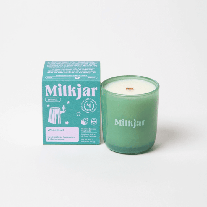 Milkjar Woodland essential oil coconut soy candle 8oz shown with the product box on a clean white background.