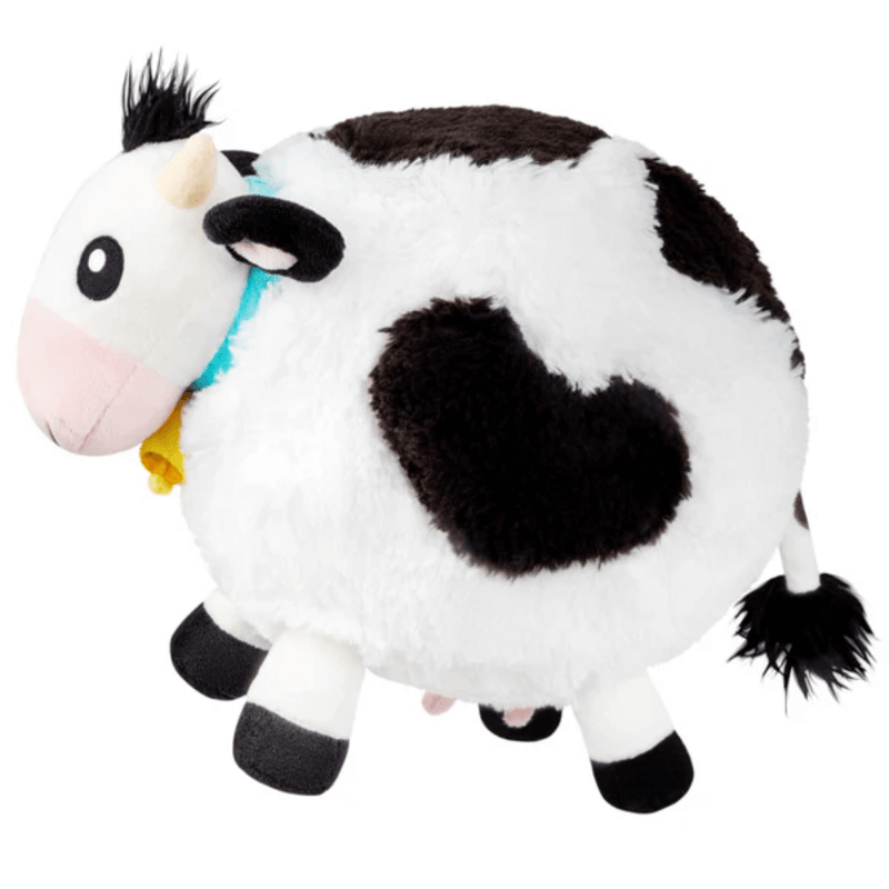 Side view of Squishable Mini Cow plush toy showing black patches and fluffy tail