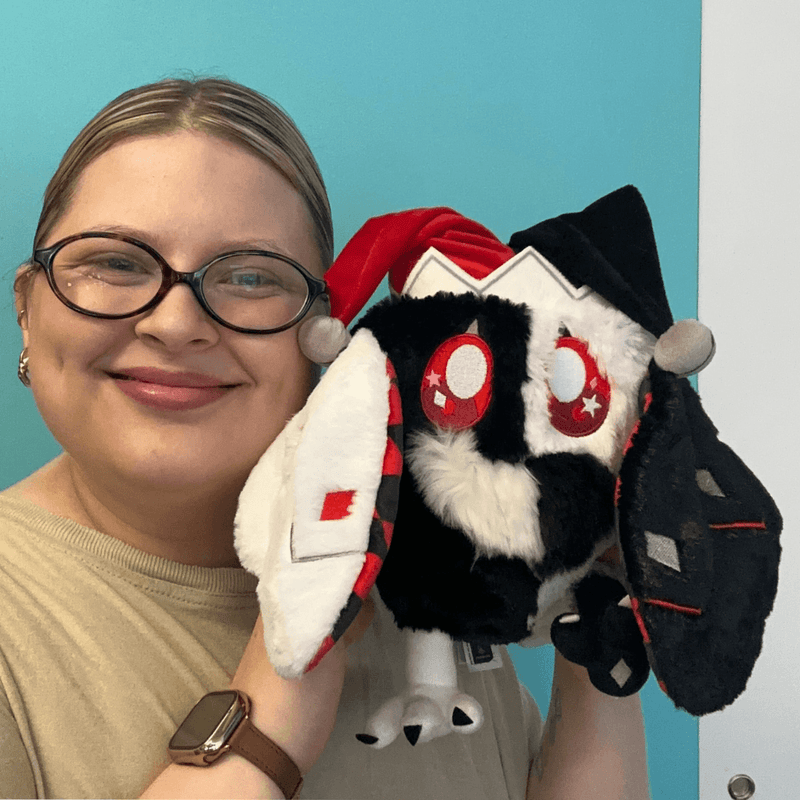 Mini Squishable Jester Mothman plush being cuddled