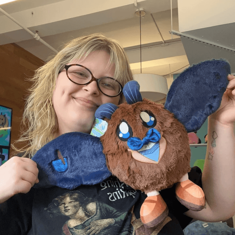 Mini Squishable Academia Mothman plush being held with its wings open