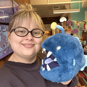 Person holding Mini Squishable Anglerfish plush showing its fluffy blue body and oversized toothy mouth