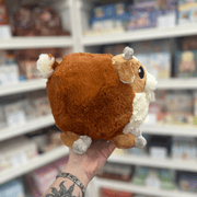 Mini Squishable Baby Goat plush toy held in hand, back view showing the rounded brown plush body, tiny tail and soft cuddly shape