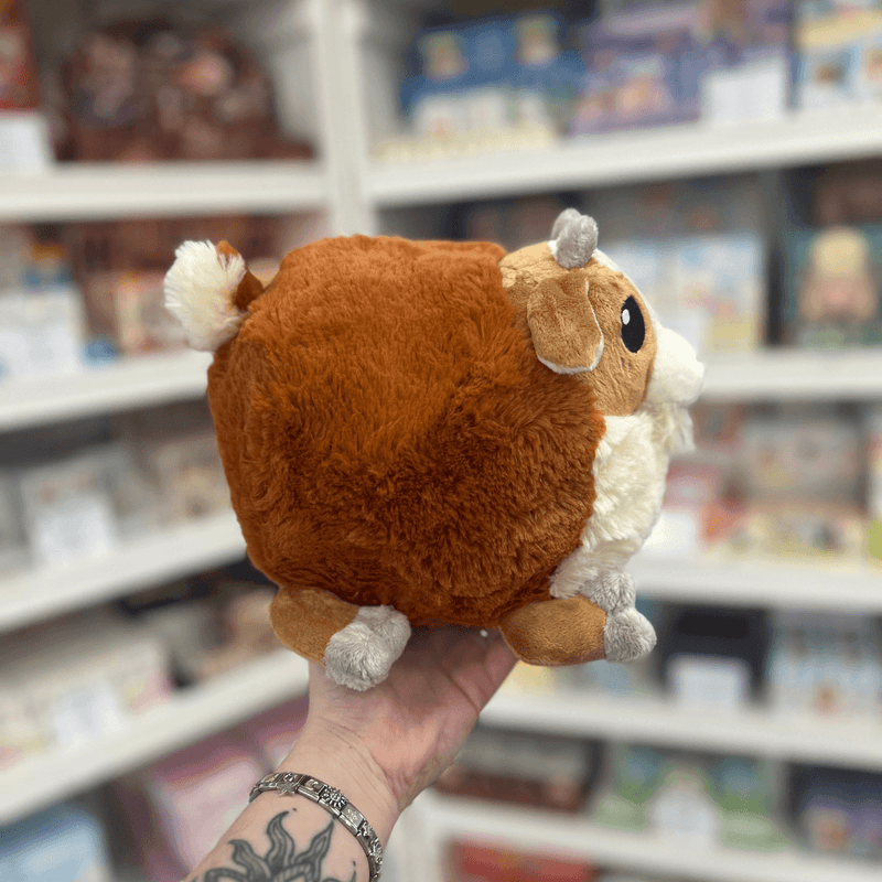 Mini Squishable Baby Goat plush toy held in hand, back view showing the rounded brown plush body, tiny tail and soft cuddly shape