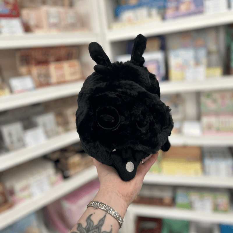 Back view of Mini Squishable Baby Mothman plush toy showing its soft black fluffy body and small moth details