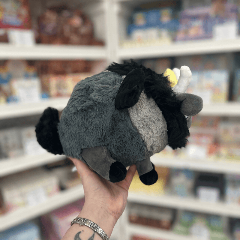 Mini Squishable Baphomet plush toy held in hand, rear angled view showing the grey plush body, black tail, black mane and folded black wings