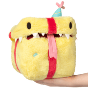 Front view of the Mini Squishable Birthday Mimic Gift plush toy with teeth, tongue and party hat