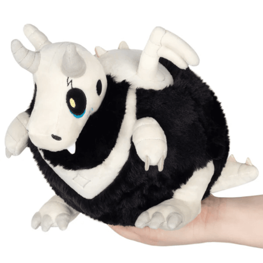 Front angled view of Mini Squishable Bone Dragon plush with black fur and white bone details