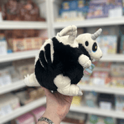 Mini Squishable Bone Dragon plush toy held in hand, rear side view showing the fluffy black body, pale wings, striped spine detail and curled tail
