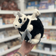 Mini Squishable Bone Dragon plush toy held in hand, angled side view showing the white skull-like head, curled horns, small wings and soft black body