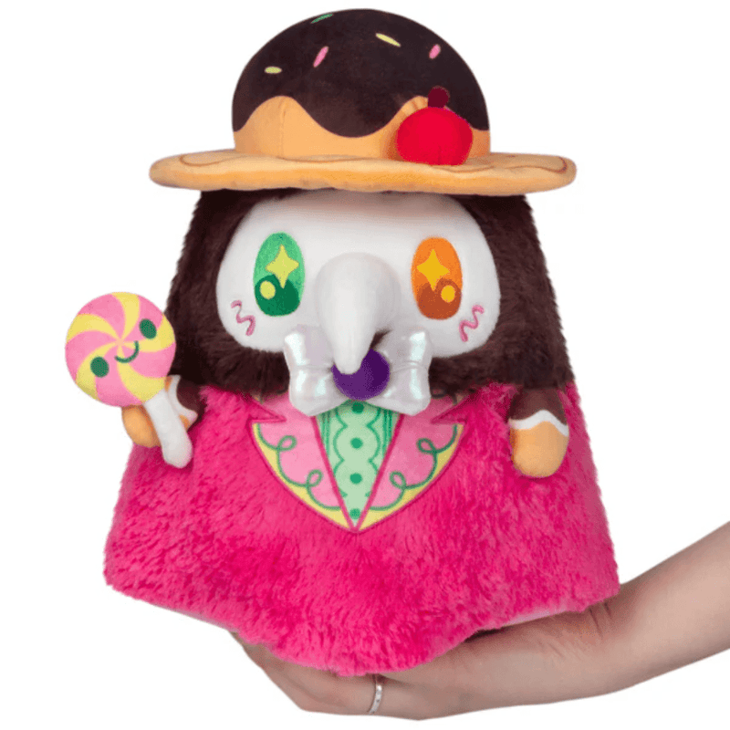 Front view of the Mini Squishable Candy Plague Doctor plush toy holding a lollipop