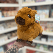 Mini Squishable Capybara plush toy held in hand, front view showing the soft brown fur, embroidered face, rounded snout and tiny ears