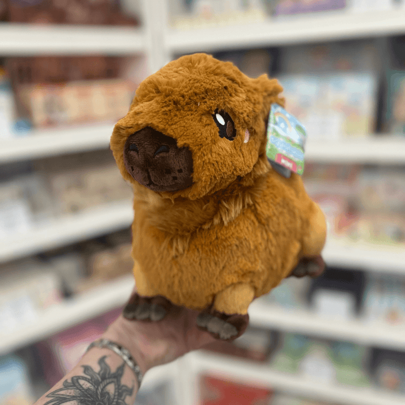 Mini Squishable Capybara plush toy held in hand, front view showing the soft brown fur, embroidered face, rounded snout and tiny ears