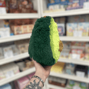 Mini Squishable Comfort Food Avocado plush toy held in hand, side view showing dark green back and soft plush texture