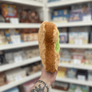 Mini Squishable Comfort Food Avocado Toast plush toy held in hand, side view showing plush toast shape
