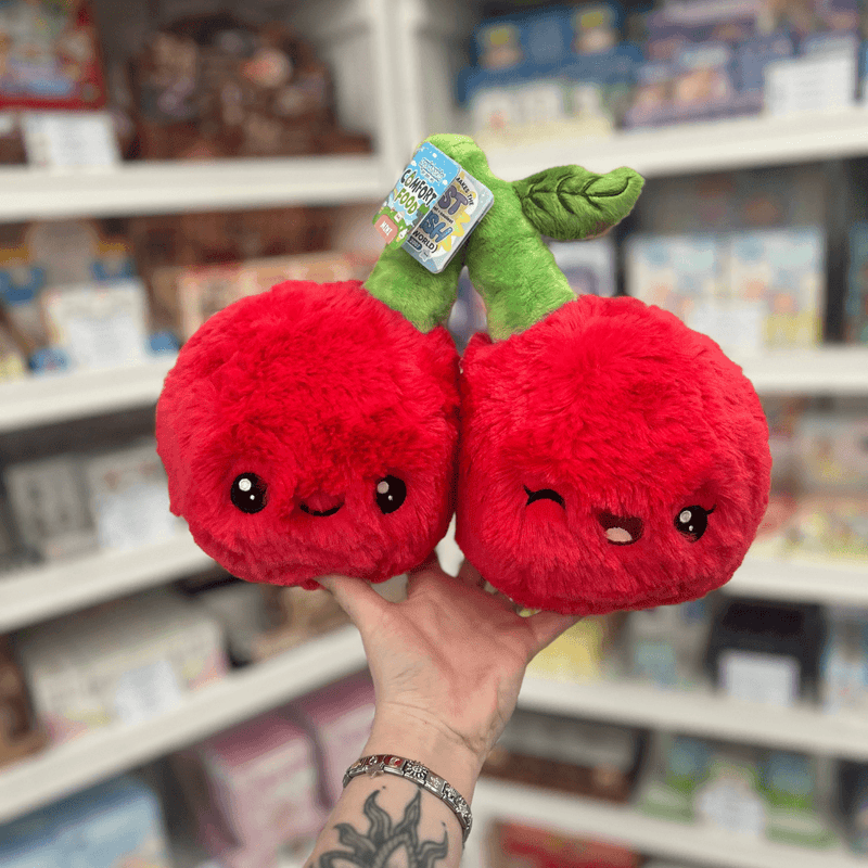 Mini Squishable Comfort Food Cherries plush toy held in hand, front view showing two bright red smiling cherries joined by soft green stems