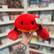 Mini Squishable Crab plush toy held in hand, front view showing the bright red body, smiling face, orange underside and large red claws